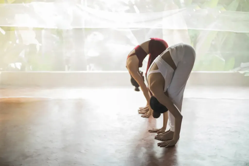 femmes faisant du yoga en se penchant en avant